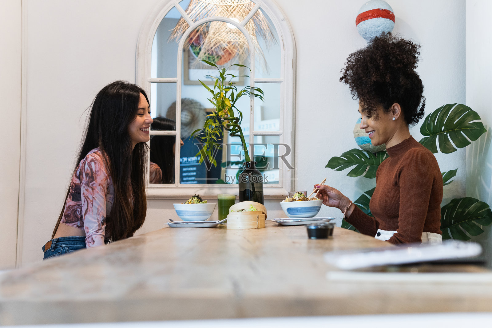 愉快友好的多民族女性在餐厅用餐照片摄影图片