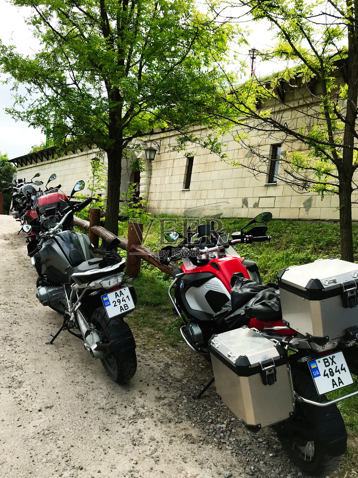 停放在绿色树木下的乡村砖建筑旁的宝马R 1250 GS冒险摩托车照片摄影图片