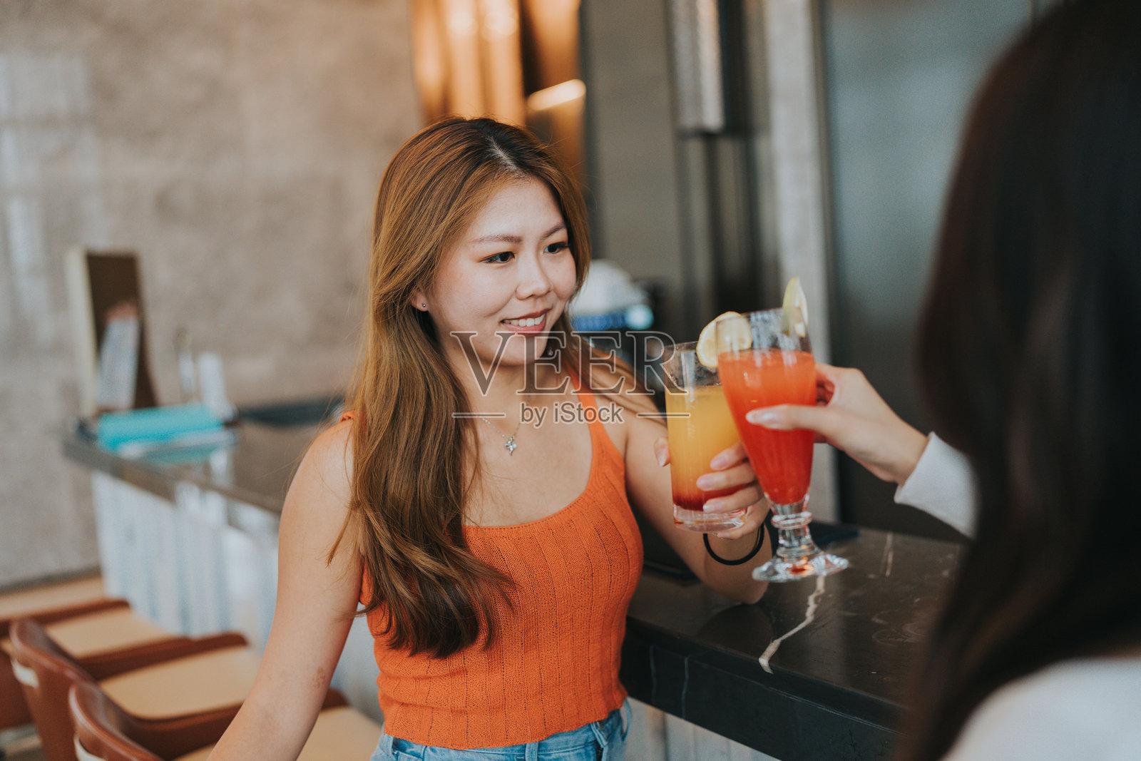 快乐的Z世代女孩在中国大湾区珠海旅行，在酒店酒吧享用饮品照片摄影图片