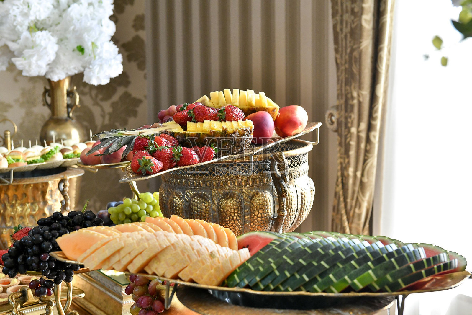 优雅的水果展示，包含葡萄、草莓和菠萝，盛放在华丽的碗中照片摄影图片