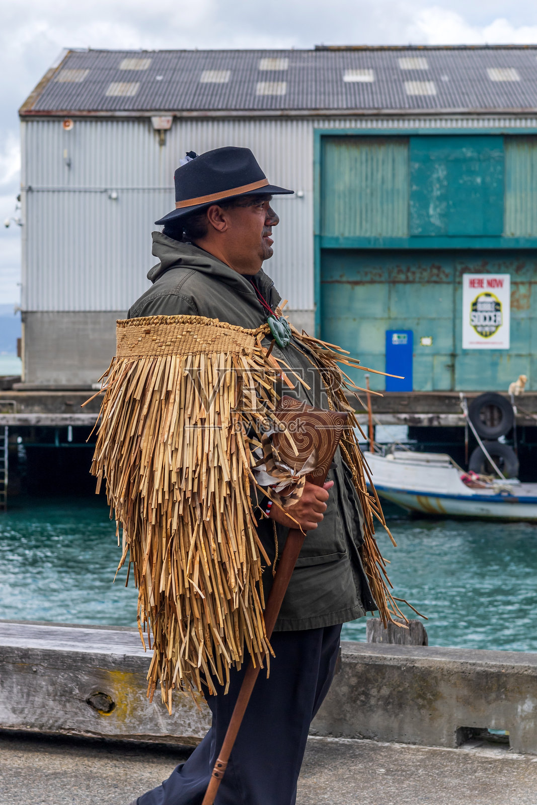 一位身披传统斗篷的毛利领袖，在惠灵顿的游行中带领着一群坚定的人们，倡导正义和文化认同。照片摄影图片