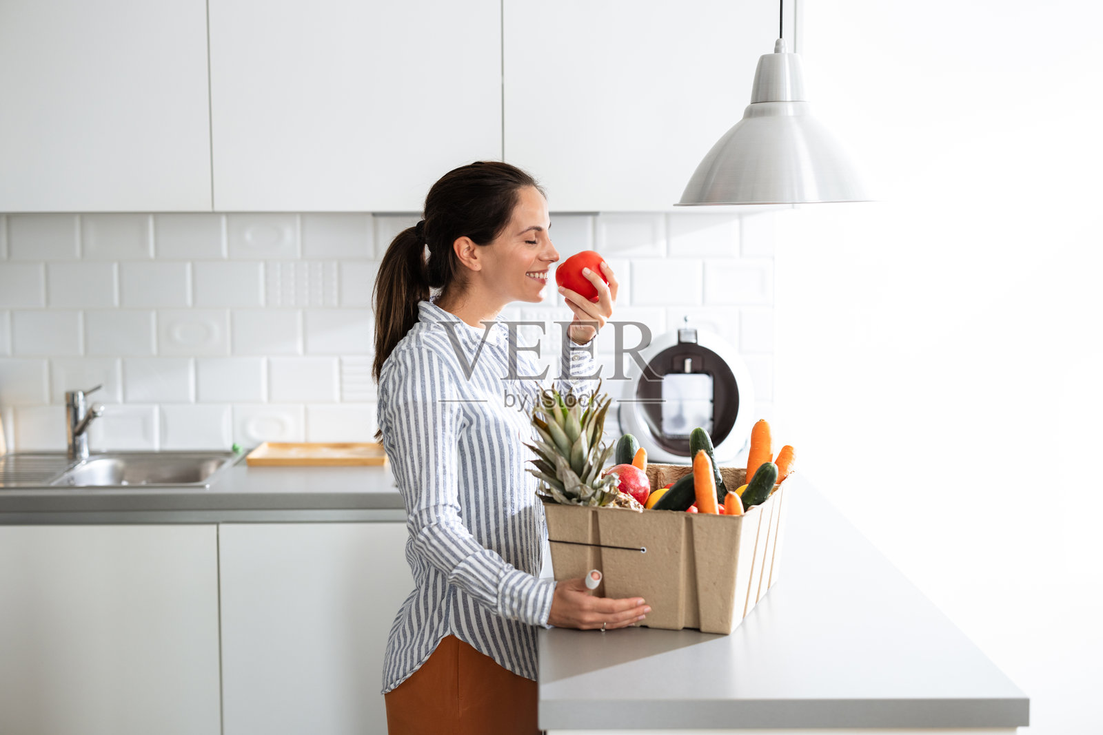 女性在现代厨房环境中享受新鲜农产品照片摄影图片