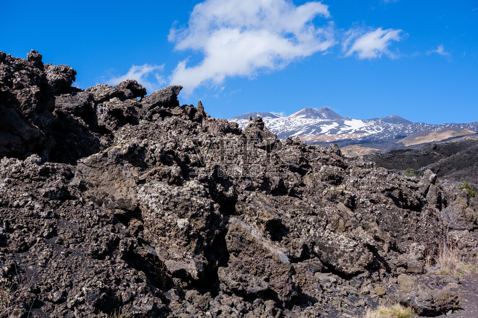 埃特纳火山的火山岩，背景是火山和晴朗的天空照片摄影图片