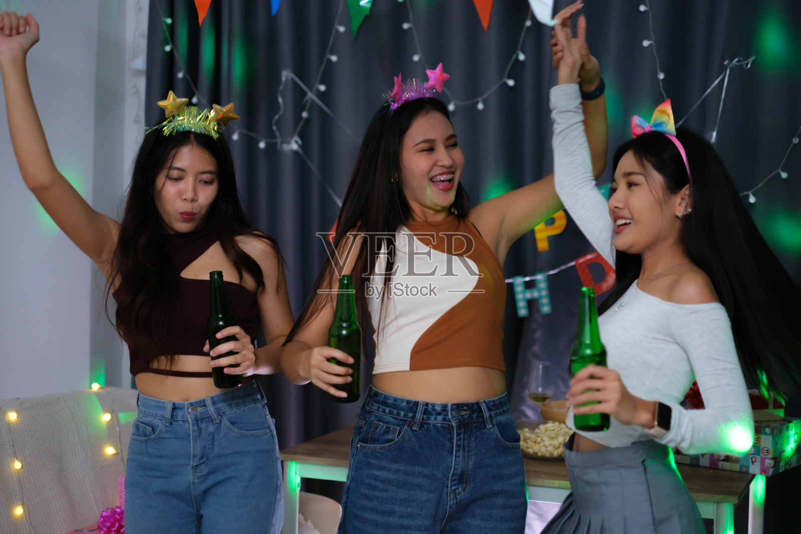 三个女孩在家里一起庆祝。照片摄影图片