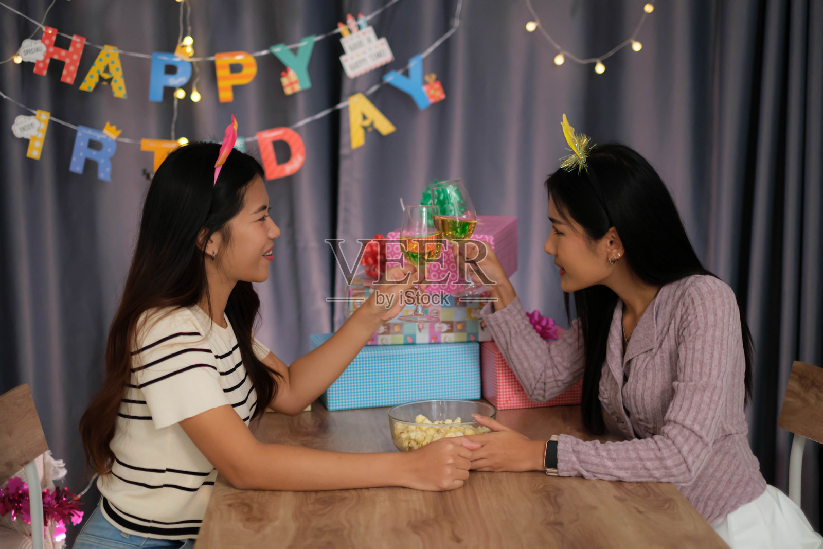 三个女孩在家里一起庆祝。照片摄影图片