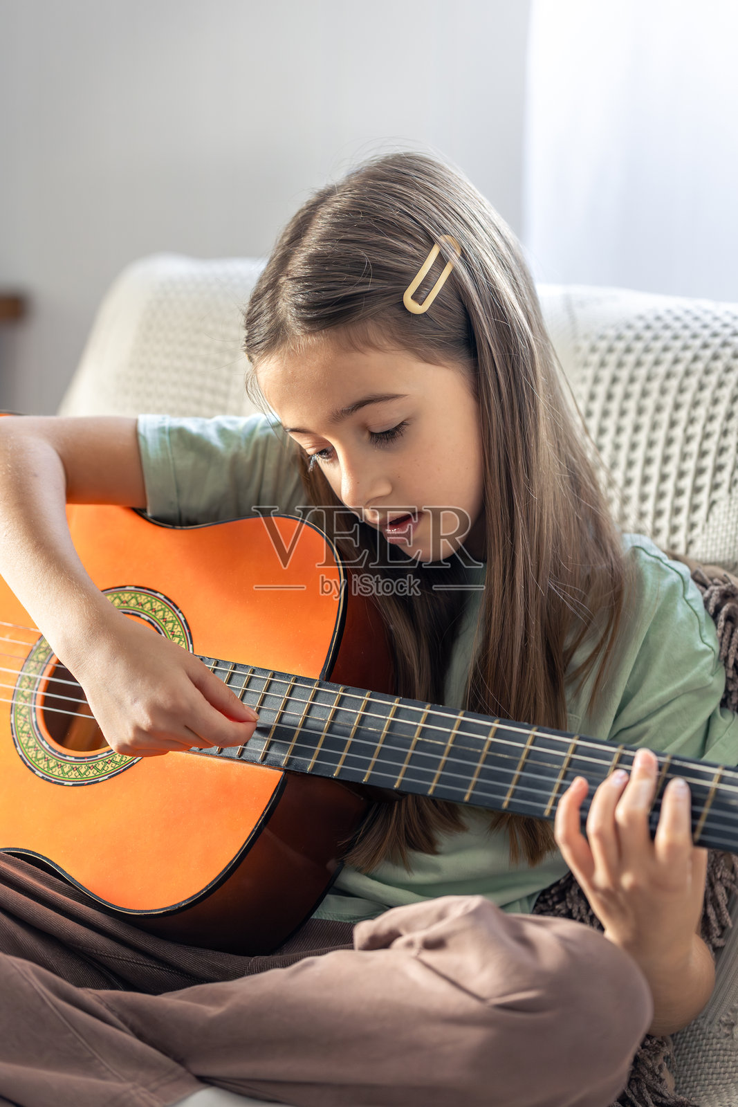 一个可爱的女孩在弹吉他。一个拿着吉他的小女孩。照片摄影图片