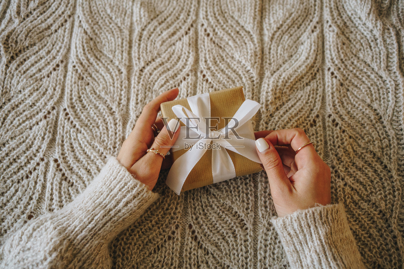 女人在温暖的针织毛毯上抱着一个圣诞礼物盒照片摄影图片