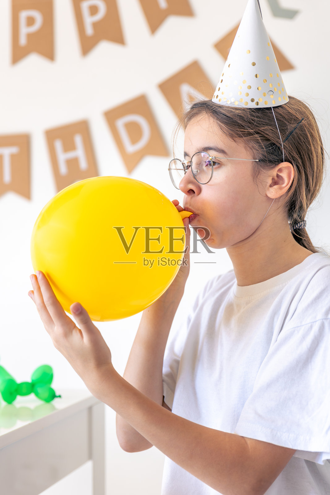 一个节日女孩在生日时给气球充气。生日概念。照片摄影图片