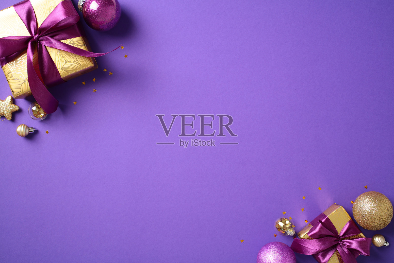 紫色背景上的金色礼品盒和装饰品的圣诞装饰。非常适合节日主题内容、圣诞促销和季节性营销材料。照片摄影图片
