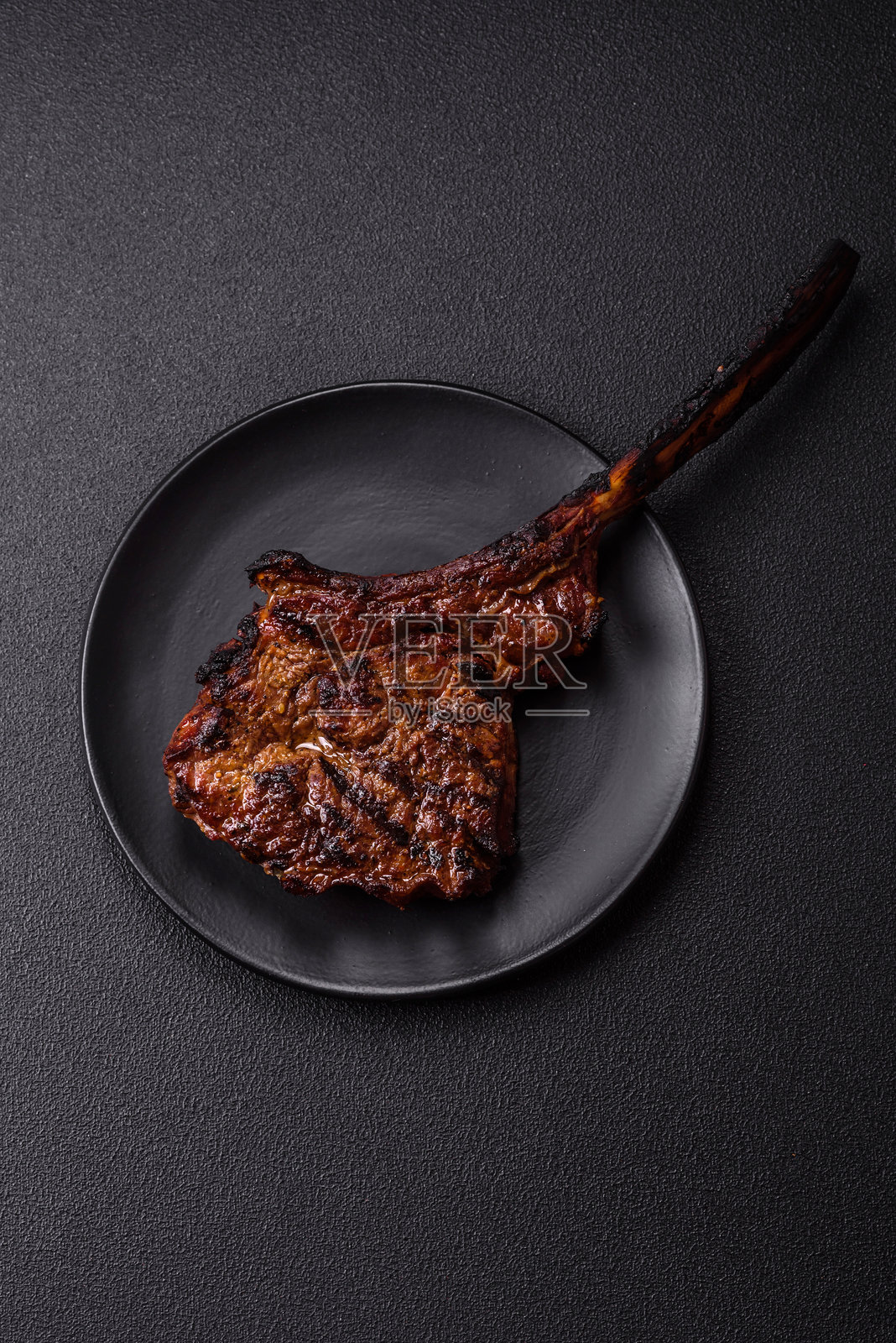 盐、香料和草药调味的烤和牛肉托马霍克牛排照片摄影图片