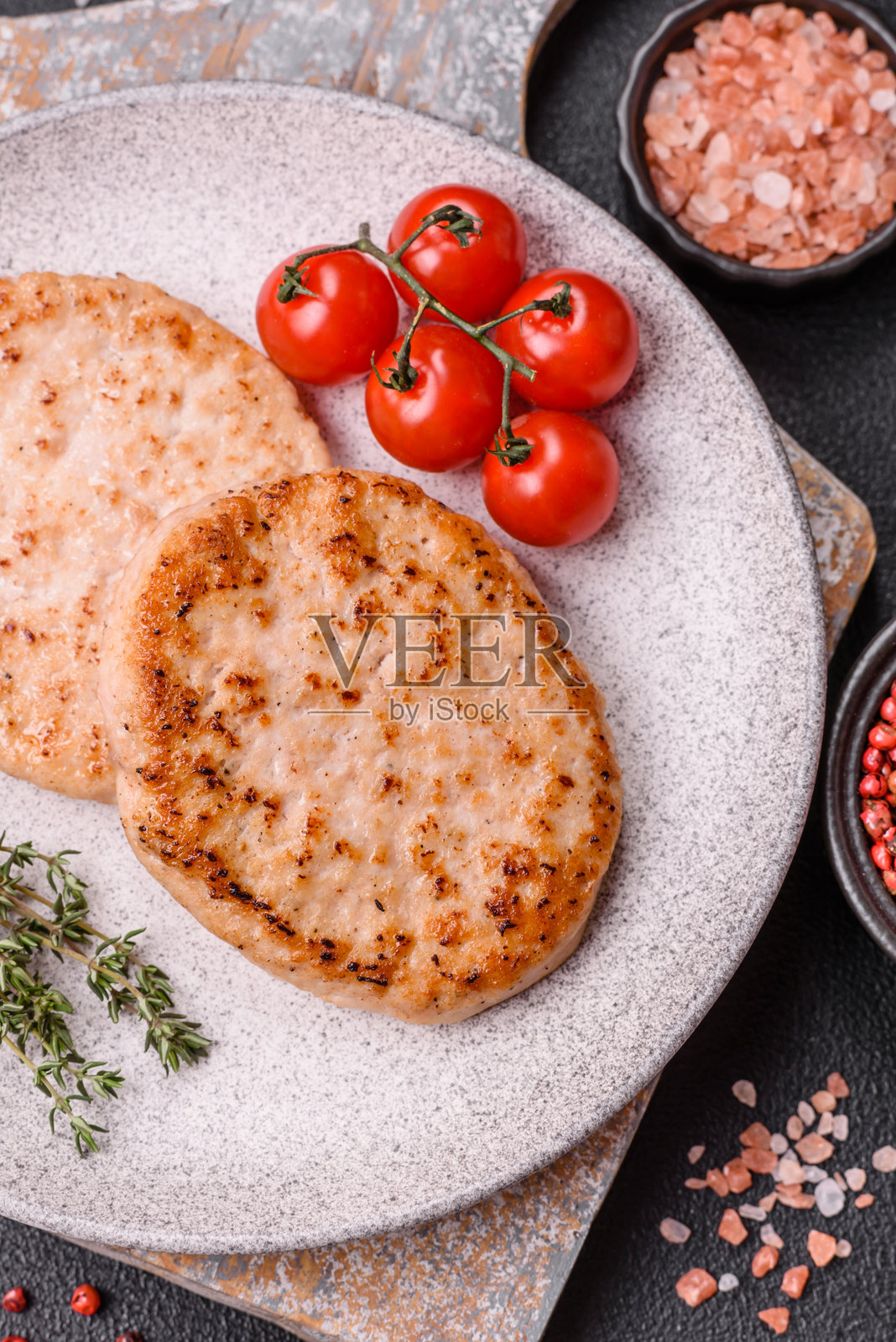 盐、香料和草药调味的烤鸡肉汉堡饼照片摄影图片