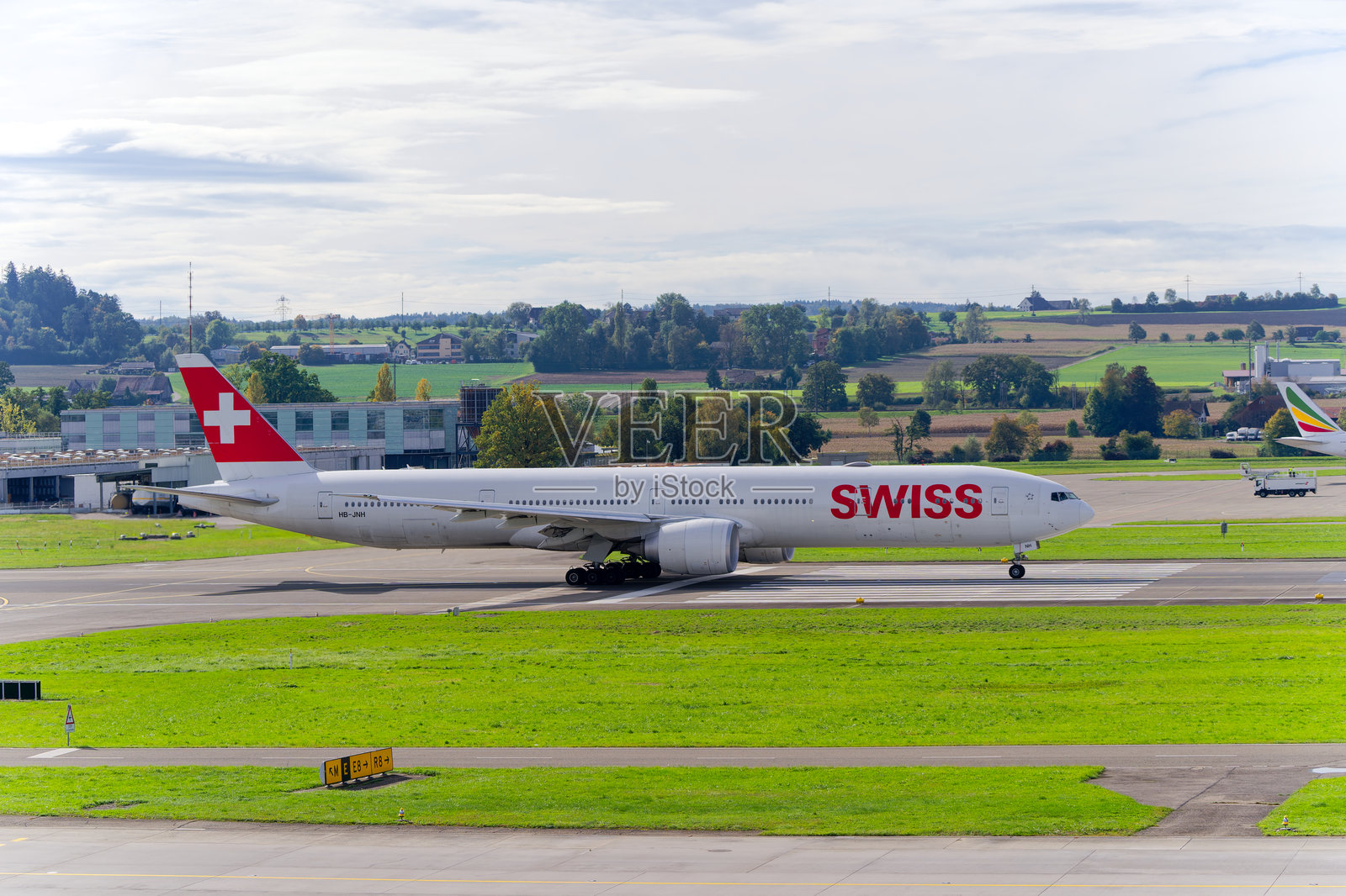 苏黎世机场34号跑道上,瑞士航空波音777-3DE(ER) HB-JNH起飞的美丽景色。照片摄影图片