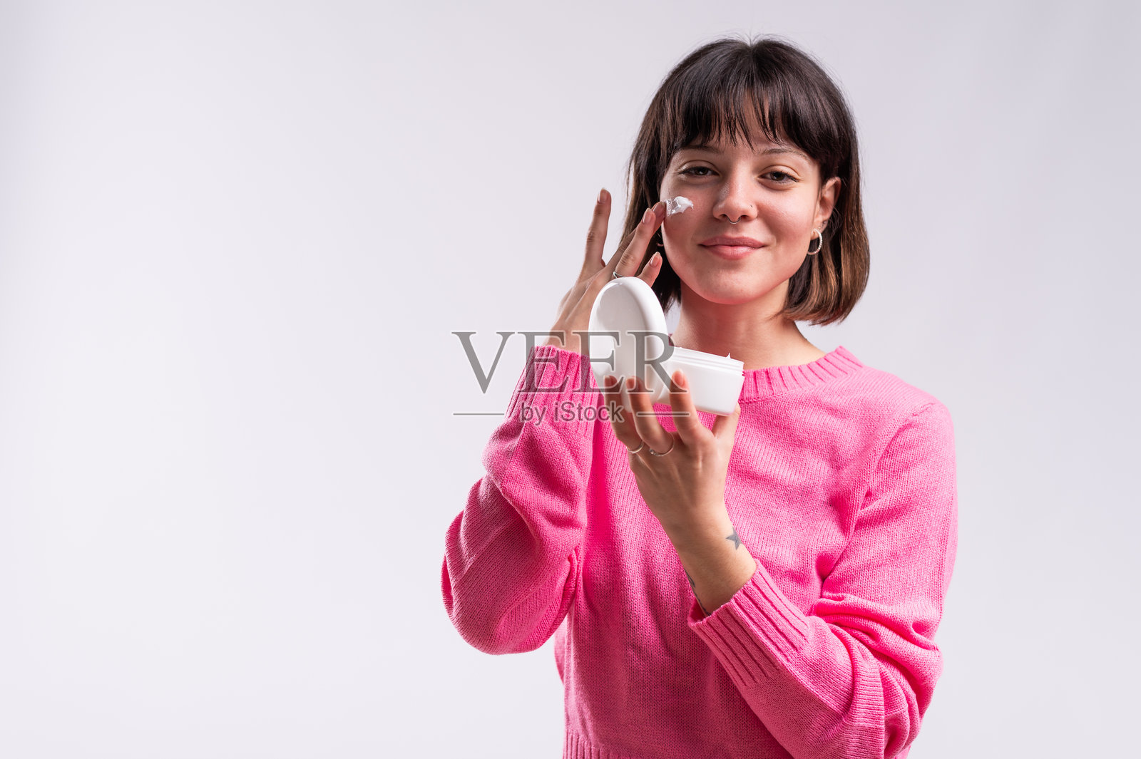 年轻女性在镜子前涂抹面霜照片摄影图片