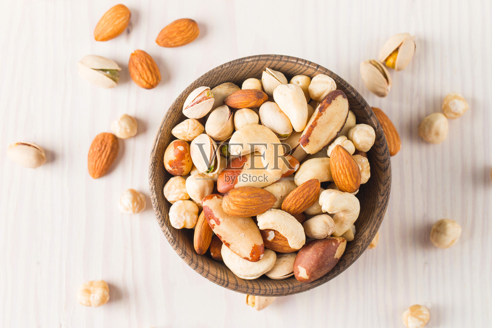 健康混合坚果在木质背景上。杏仁、榛子、腰果、花生、开心果、巴西坚果照片摄影图片