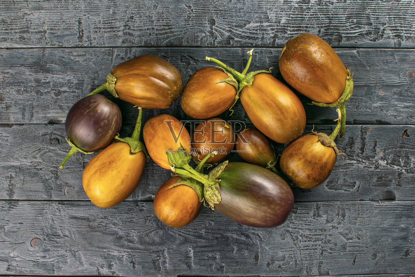 原始棕色茄子放在质朴的木质表面，展现出乡村魅力和自然质感照片摄影图片