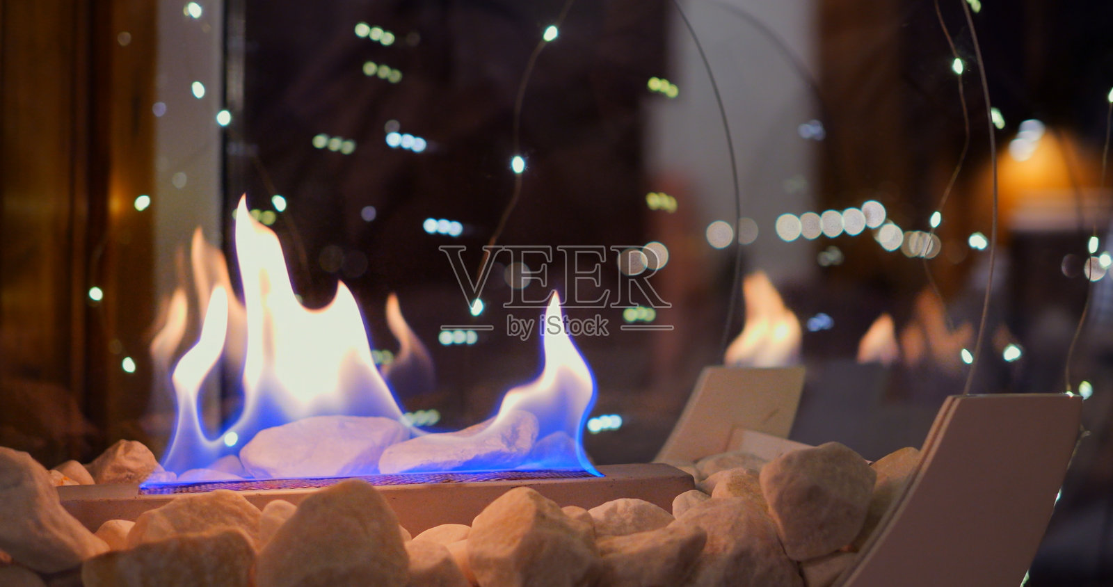 生物火炉的圣诞装饰营造出神奇的节日氛围。火焰的温暖与闪烁的灯光相结合，为冬季庆祝活动带来舒适和快乐。圣诞节的生物火炉。照片摄影图片