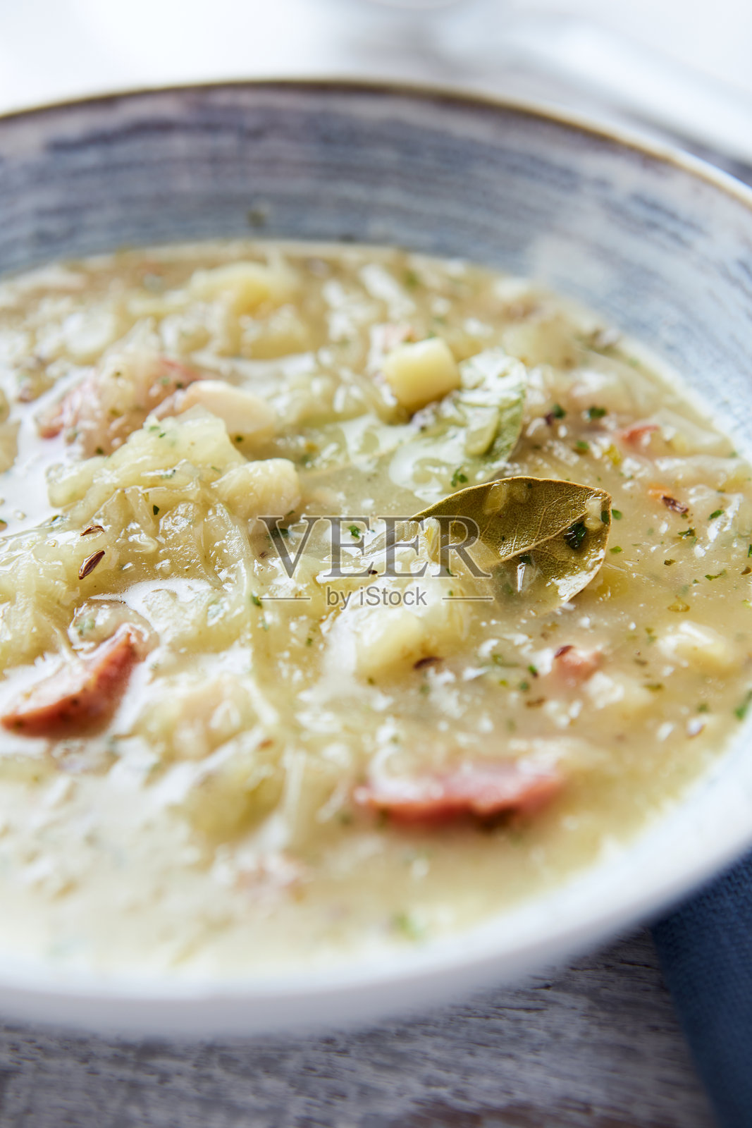 木质背景上的卷心菜汤特写。照片摄影图片