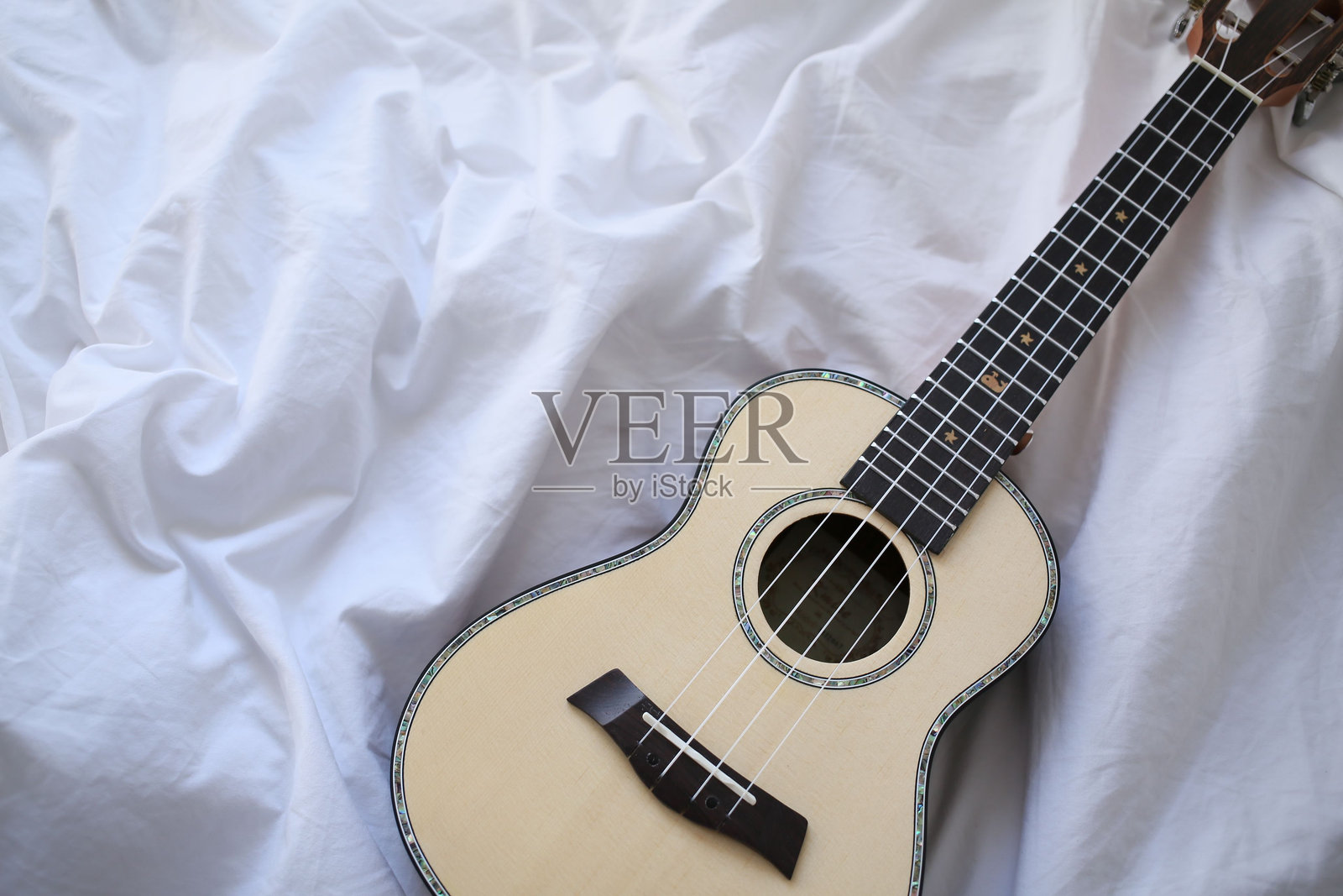 白色布料上的尤克里里照片摄影图片