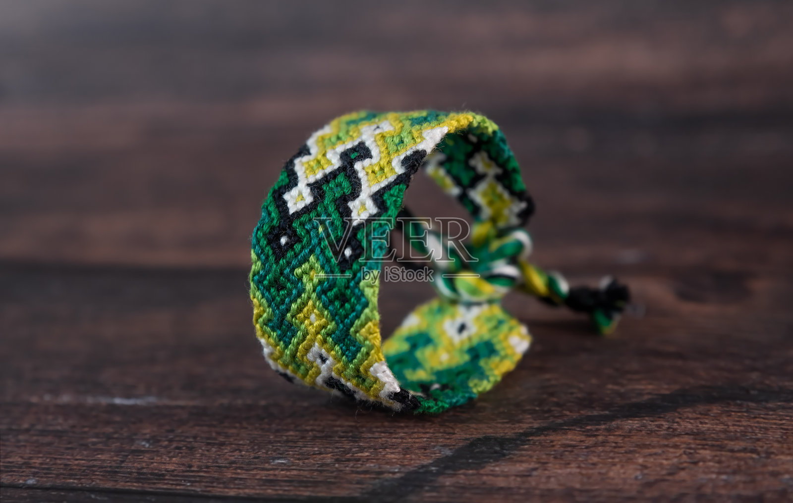 用线手工编织的五彩缤纷的友情手链，绑在一起，背景为白色。照片摄影图片