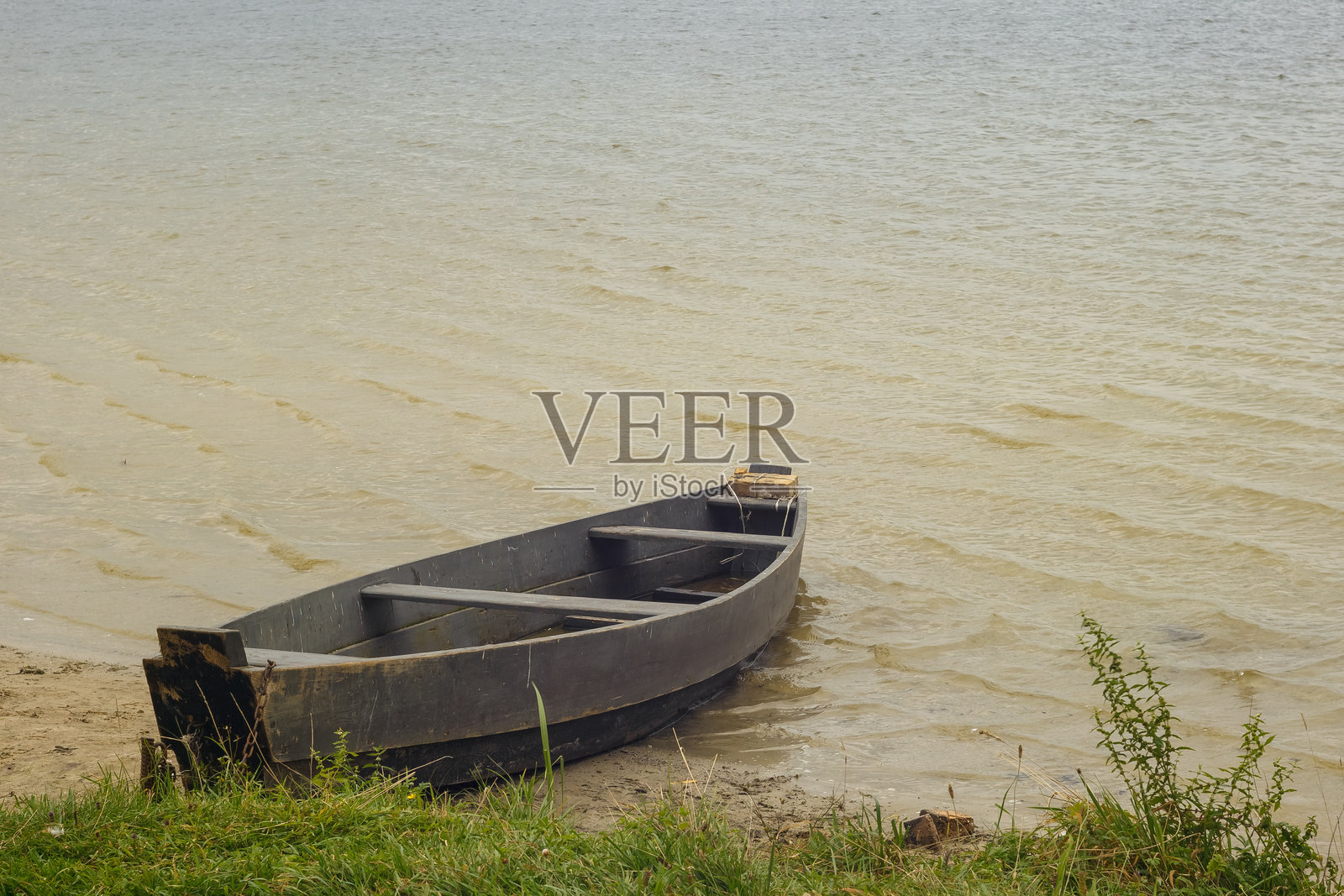 停泊在湖泊浅水区的旧乡村木制渔船照片摄影图片