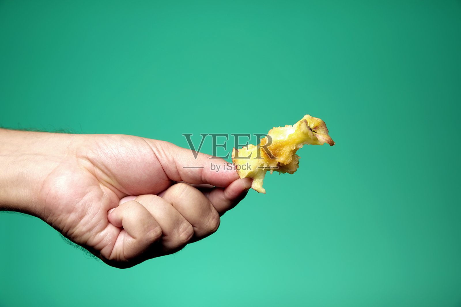 一个被吃过的苹果，握在果梗上照片摄影图片