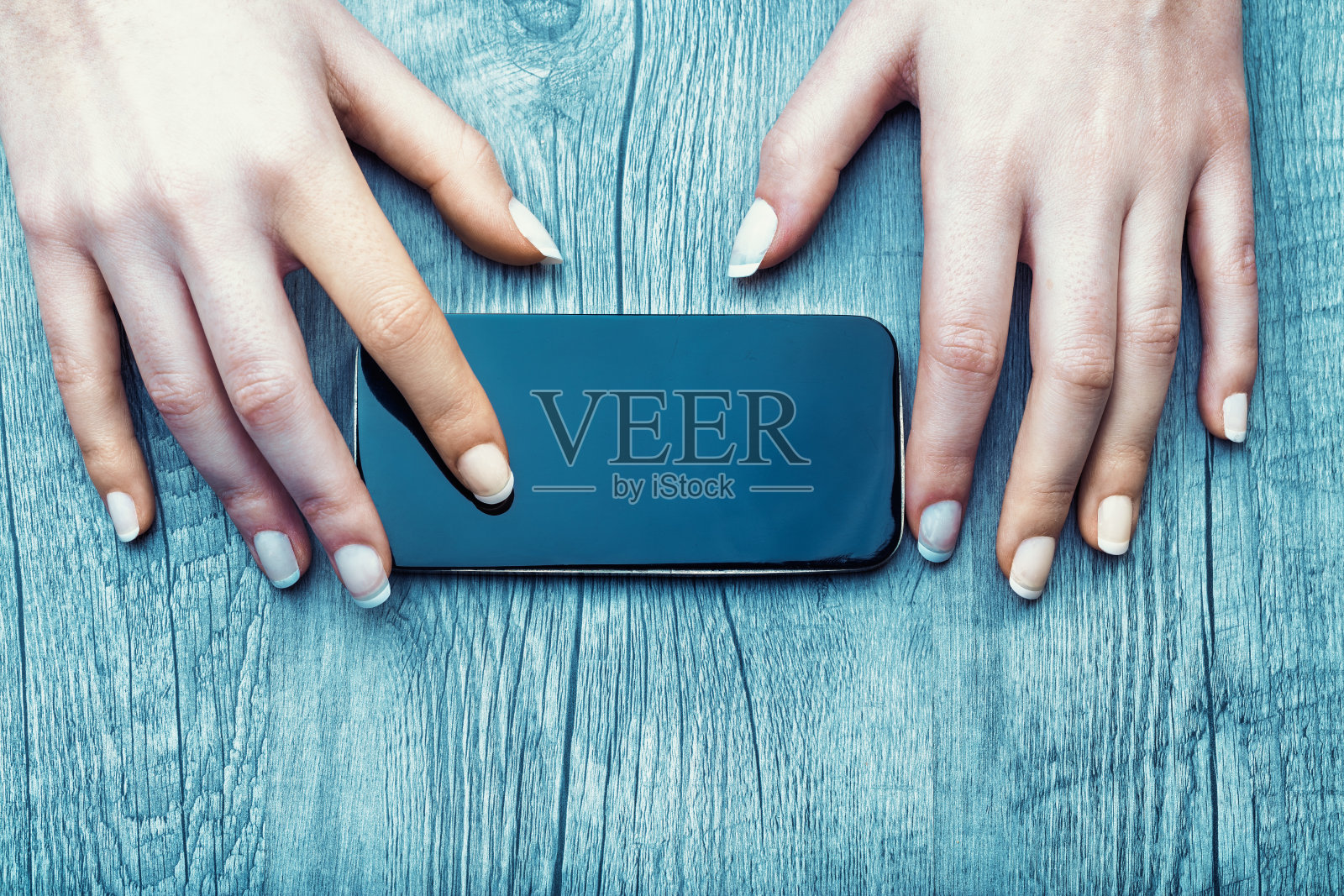 手掌在纹理木质表面上框住智能手机，平静地照片摄影图片