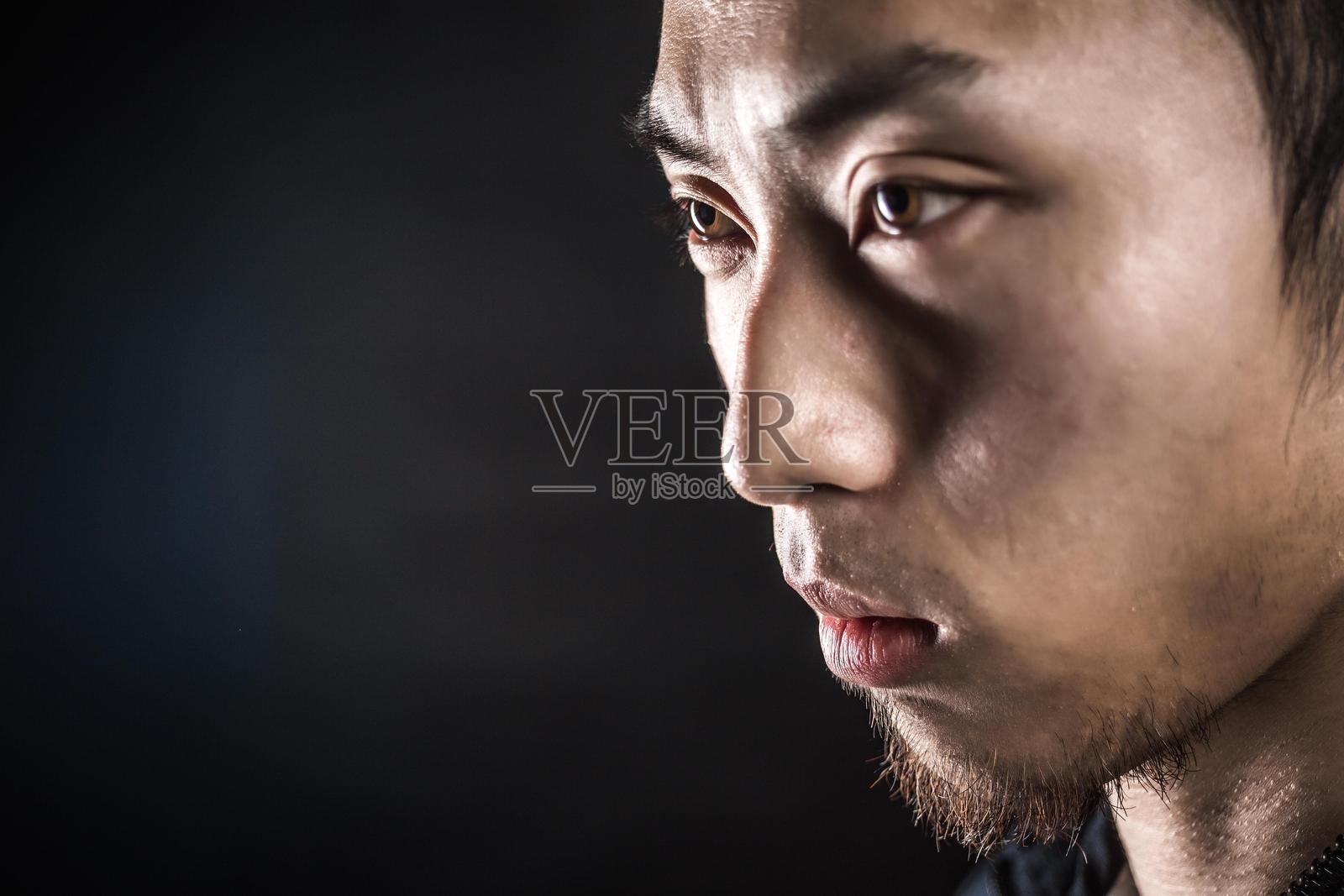 一位坚定的年轻亚洲男子侧目而视的肖像照片摄影图片