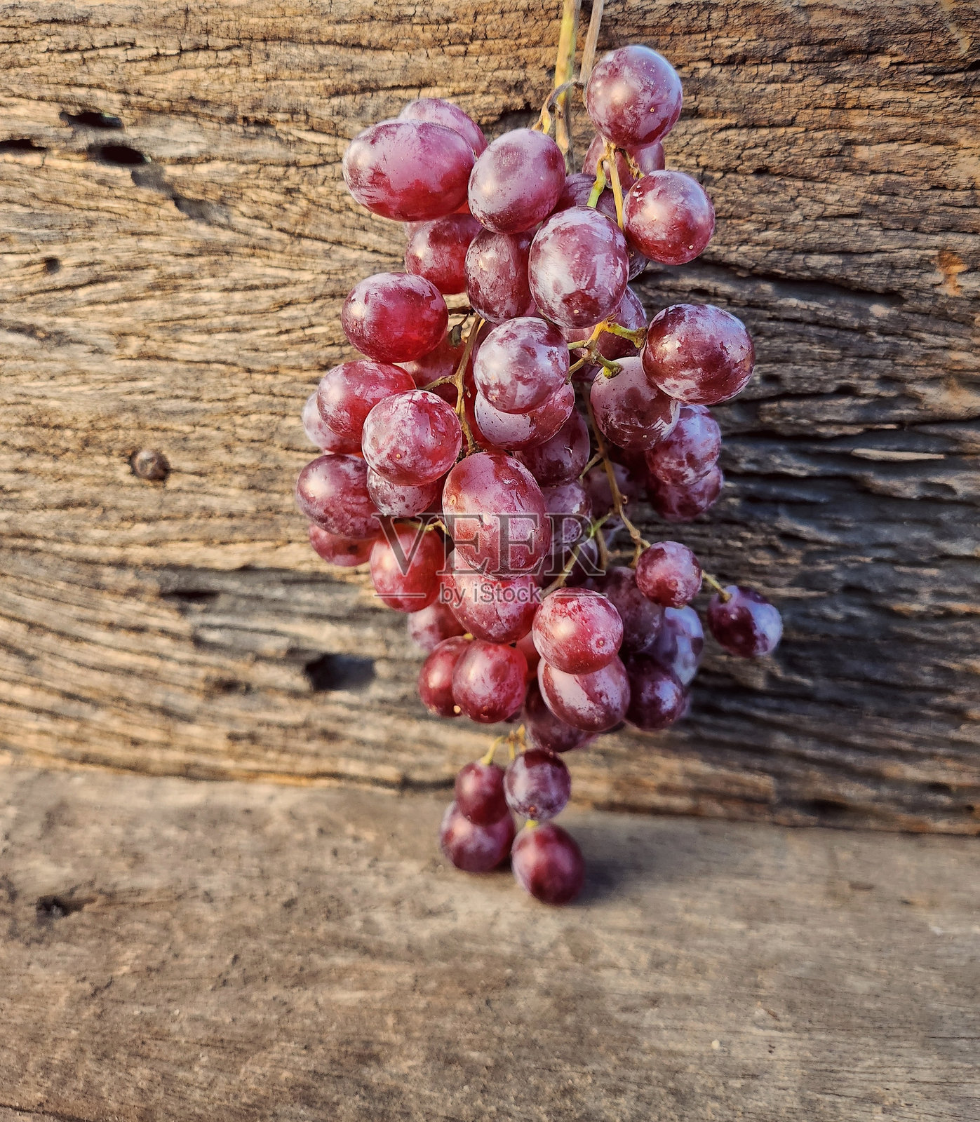 红色葡萄果实在木质背景上照片摄影图片