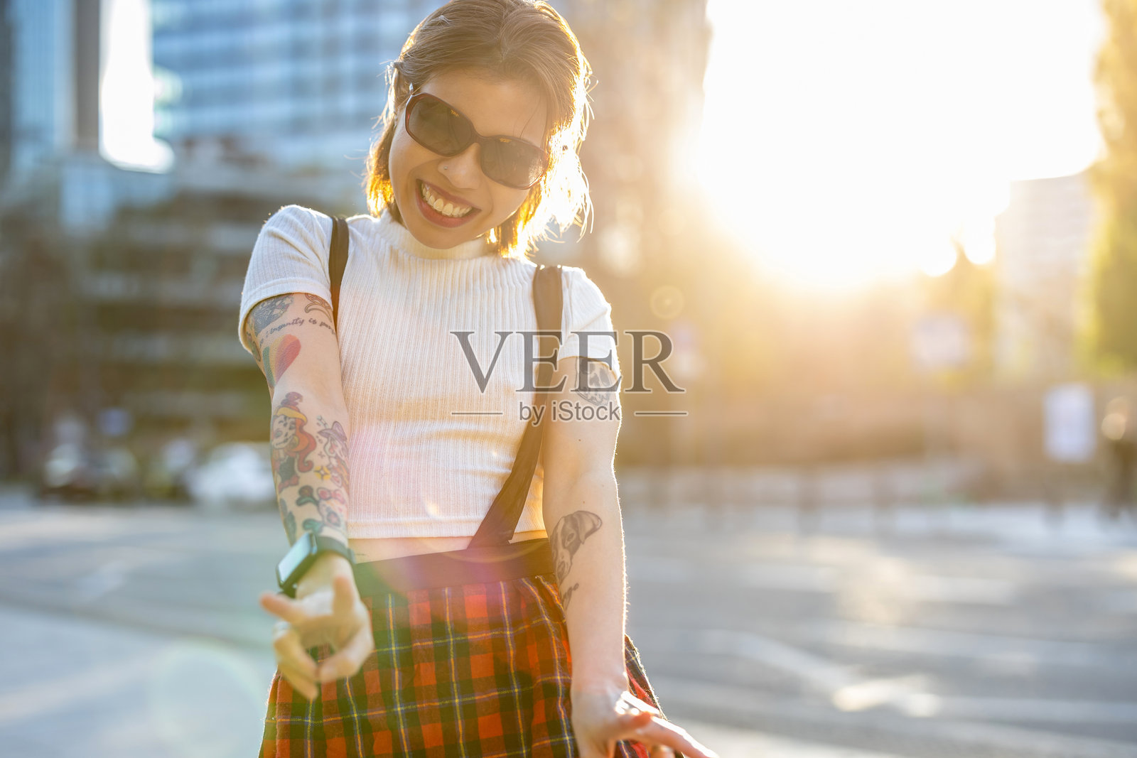 微笑的年轻女性在城市街道上做手势照片摄影图片