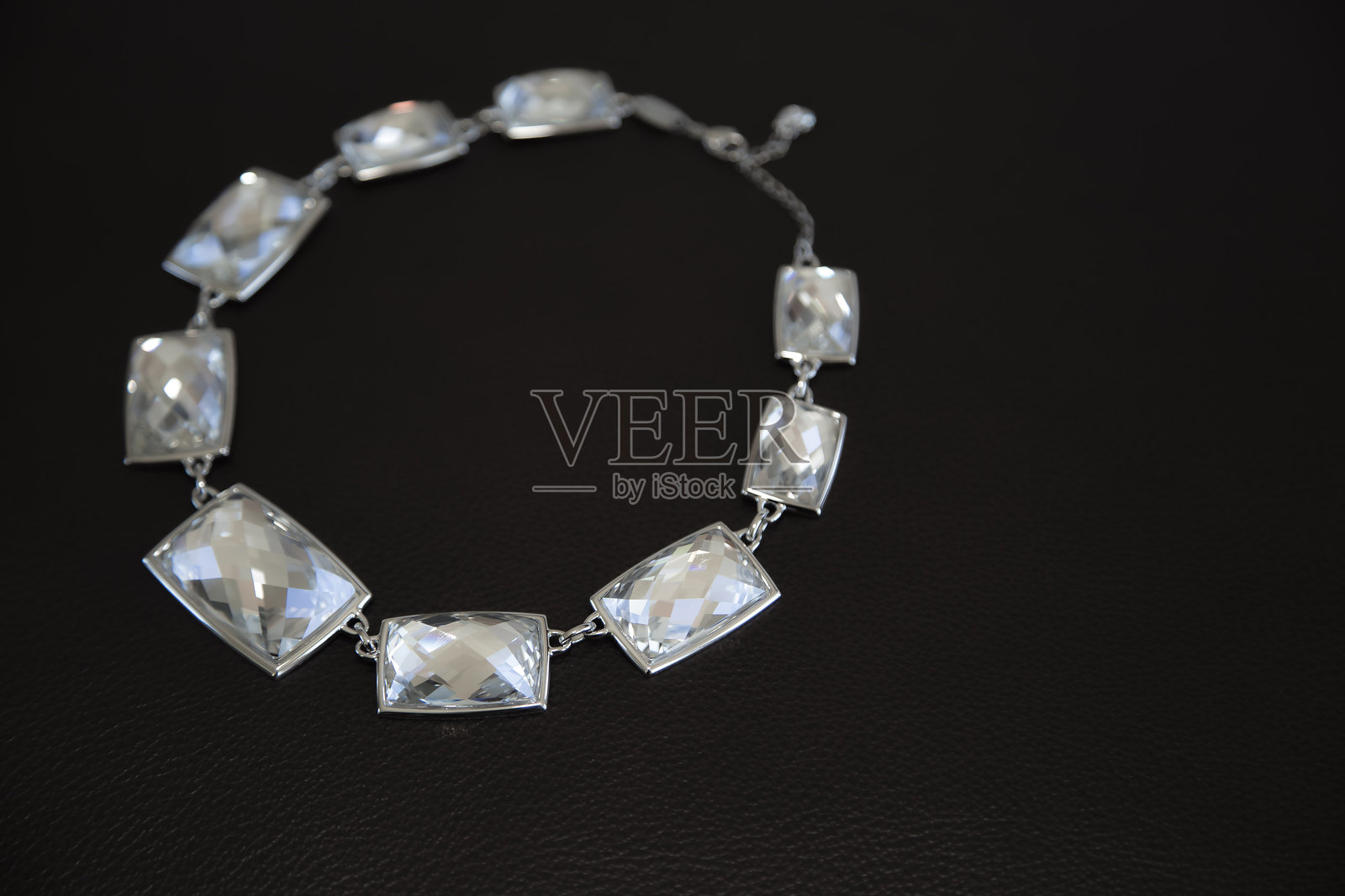 在黑色表面上展示的优雅水晶项链，突显其精致的设计。照片摄影图片