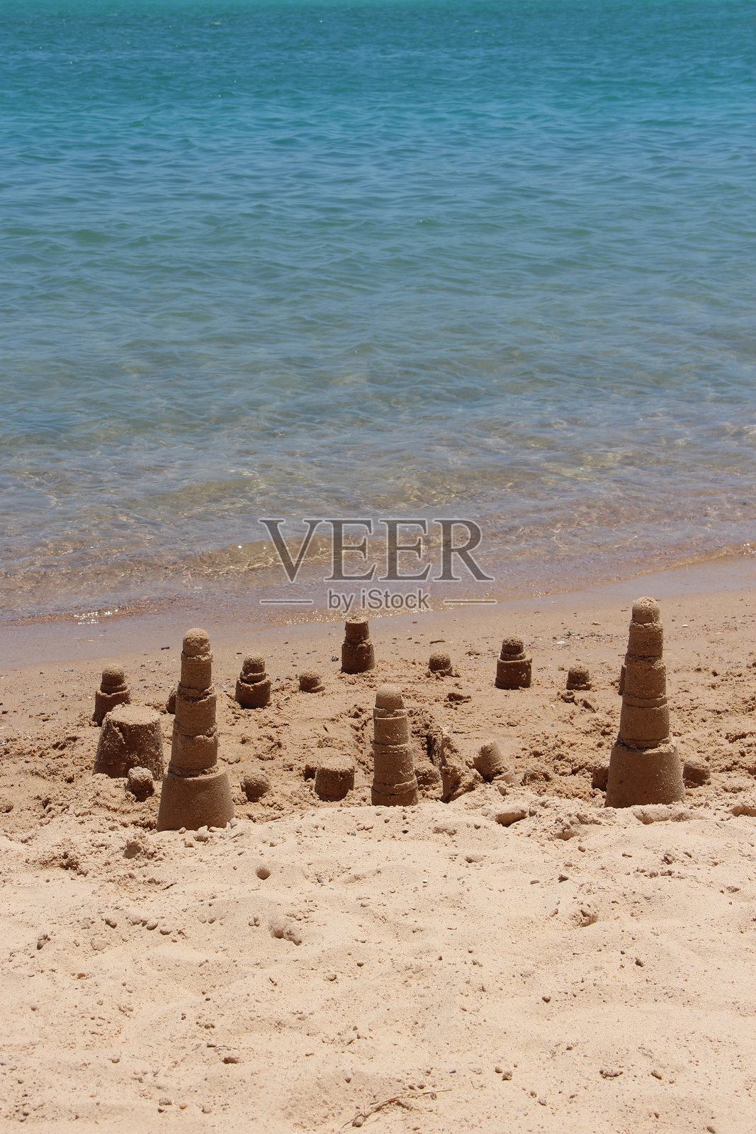 孩子们在海边建造的沙屋。夏季假期。放松的概念照片摄影图片