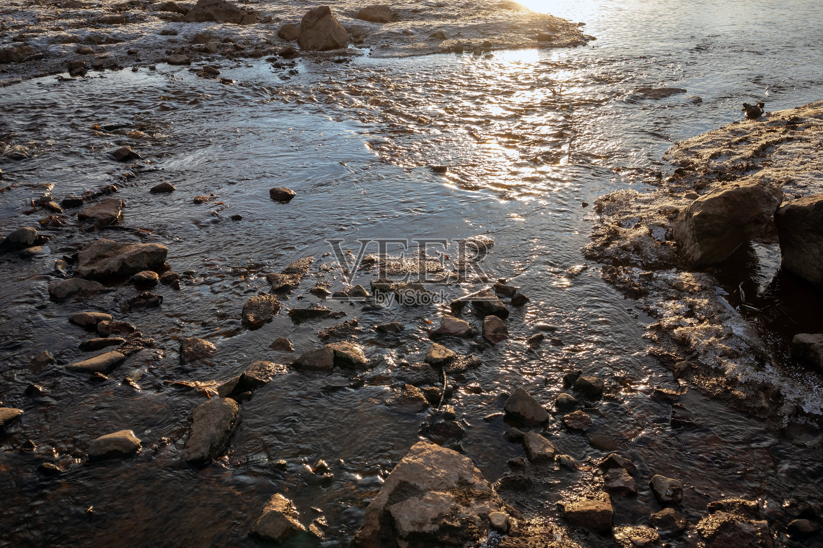 浅溪流淌的水在剪影中照片摄影图片