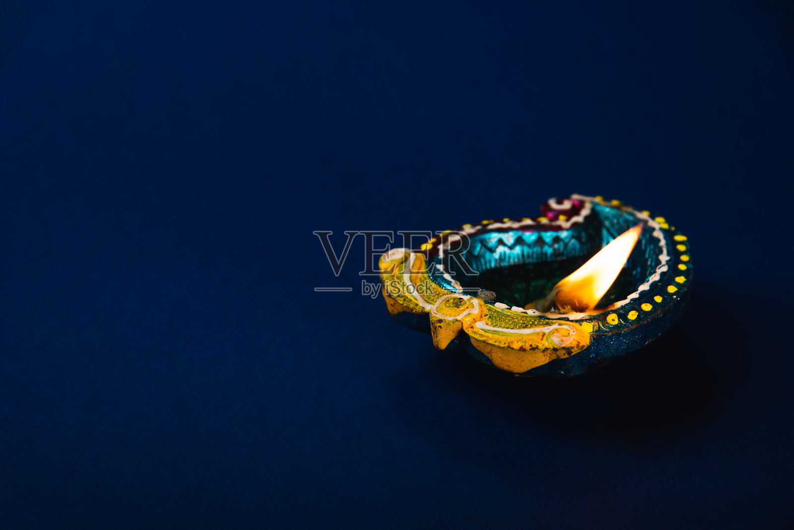 抽象的排灯节背景，闪耀的泥油灯。明亮的色调象征着繁荣与快乐。非常适合排灯节、胡里节和宗教主题的邀请函。闪亮的灯光照亮夜空。照片摄影图片