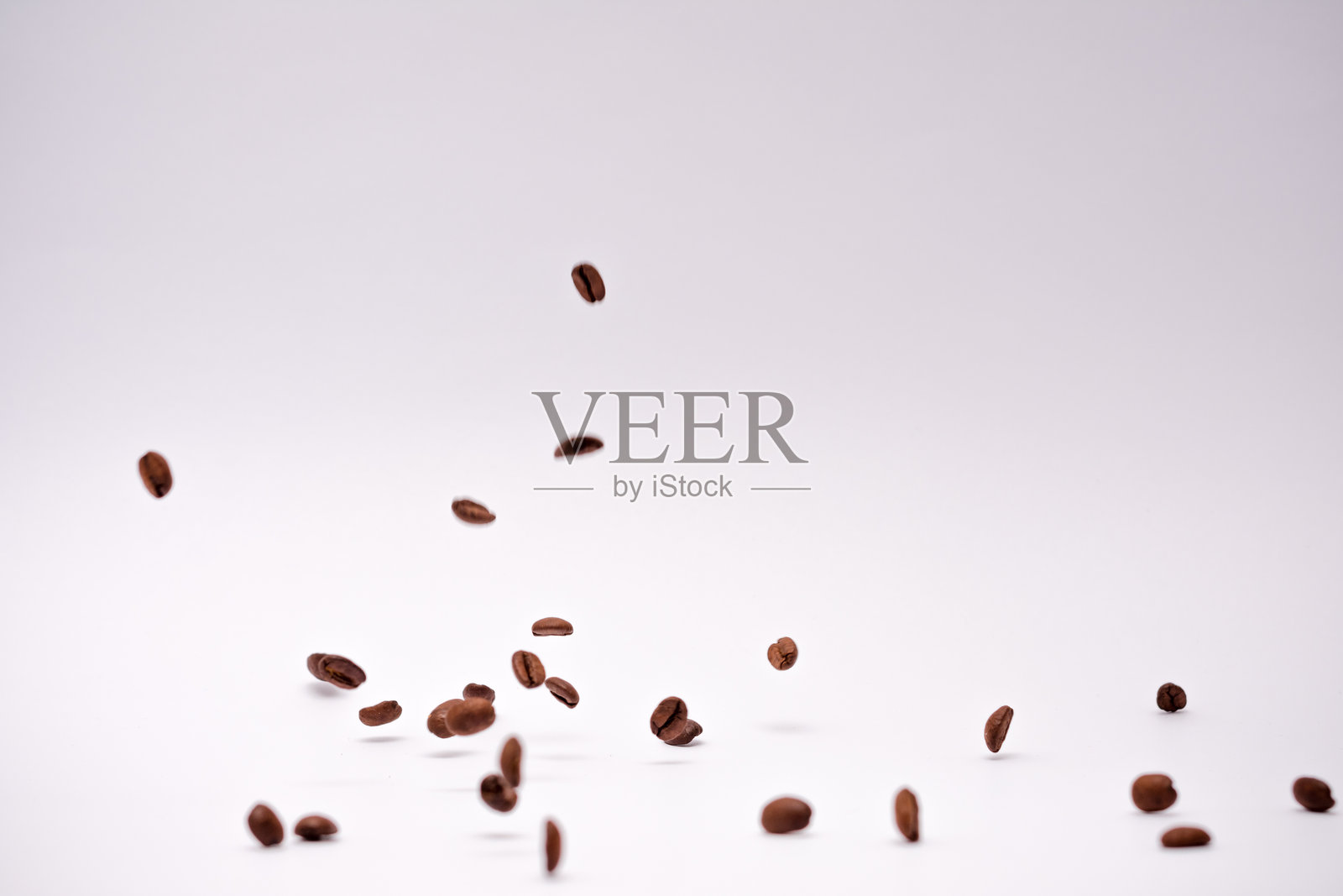 大量咖啡豆散落在白色背景上照片摄影图片