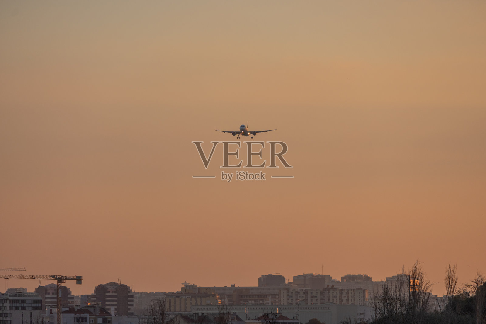 葡萄牙航空的飞机在日落时分降落在里斯本机场照片摄影图片