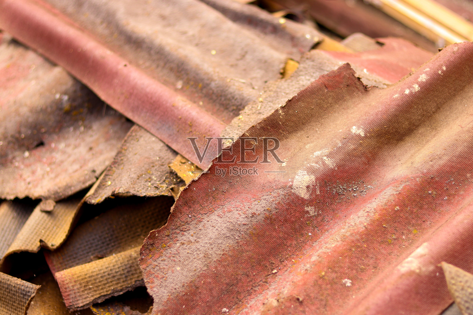 旧的非常危险的石棉屋顶。Ondulin废料。Ondulin板。用沥青浸渍的波纹沥青纸板，形状像石板。照片摄影图片