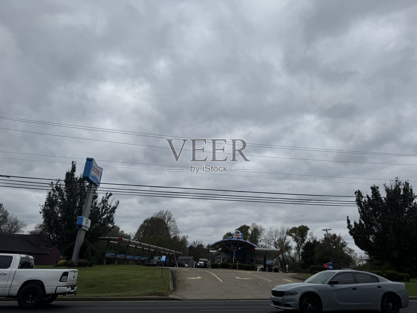 阴云密布的天空下，一处路边加油站和警察在进行例行检查。照片摄影图片