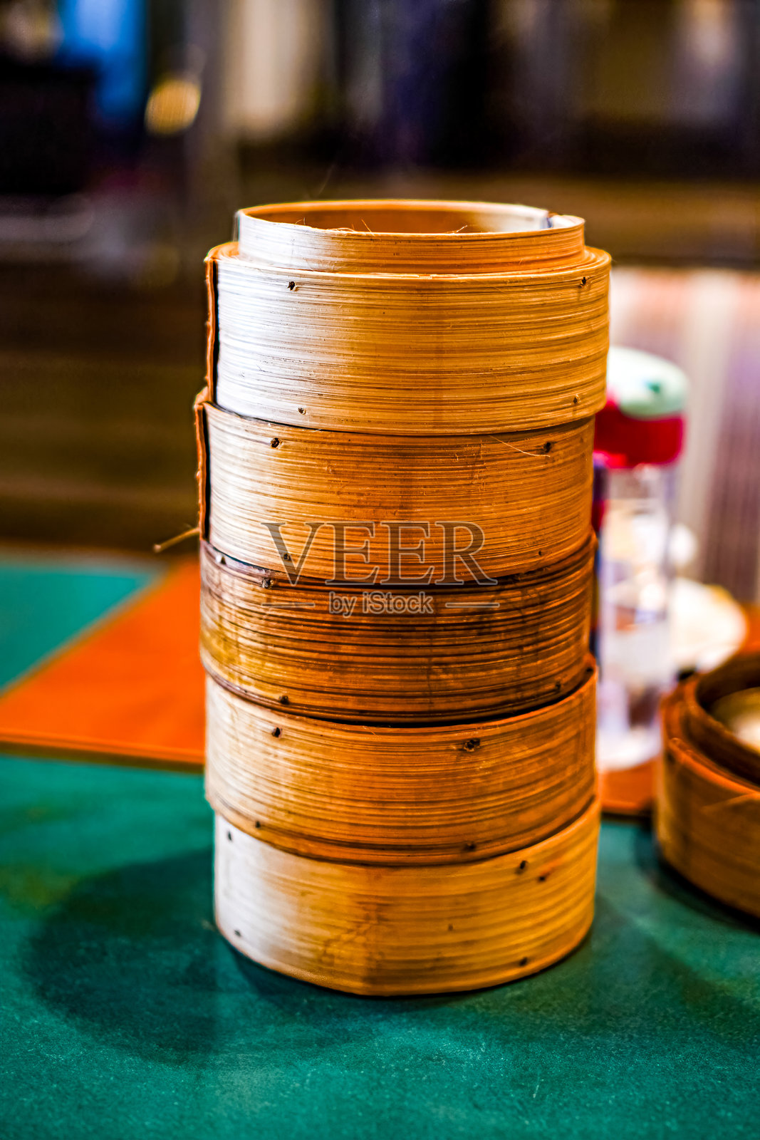 餐桌上堆放着用来装点心菜单的竹制蒸笼的垂直图像。照片摄影图片