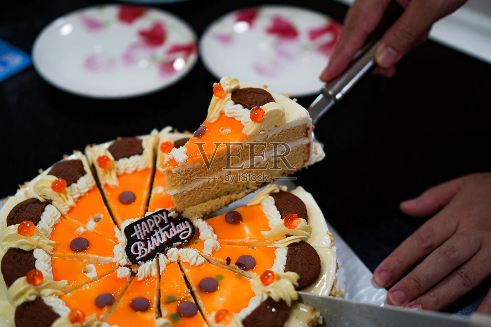 图为在家庭成员的生日庆典上从生日蛋糕上切下的一片蛋糕。照片摄影图片