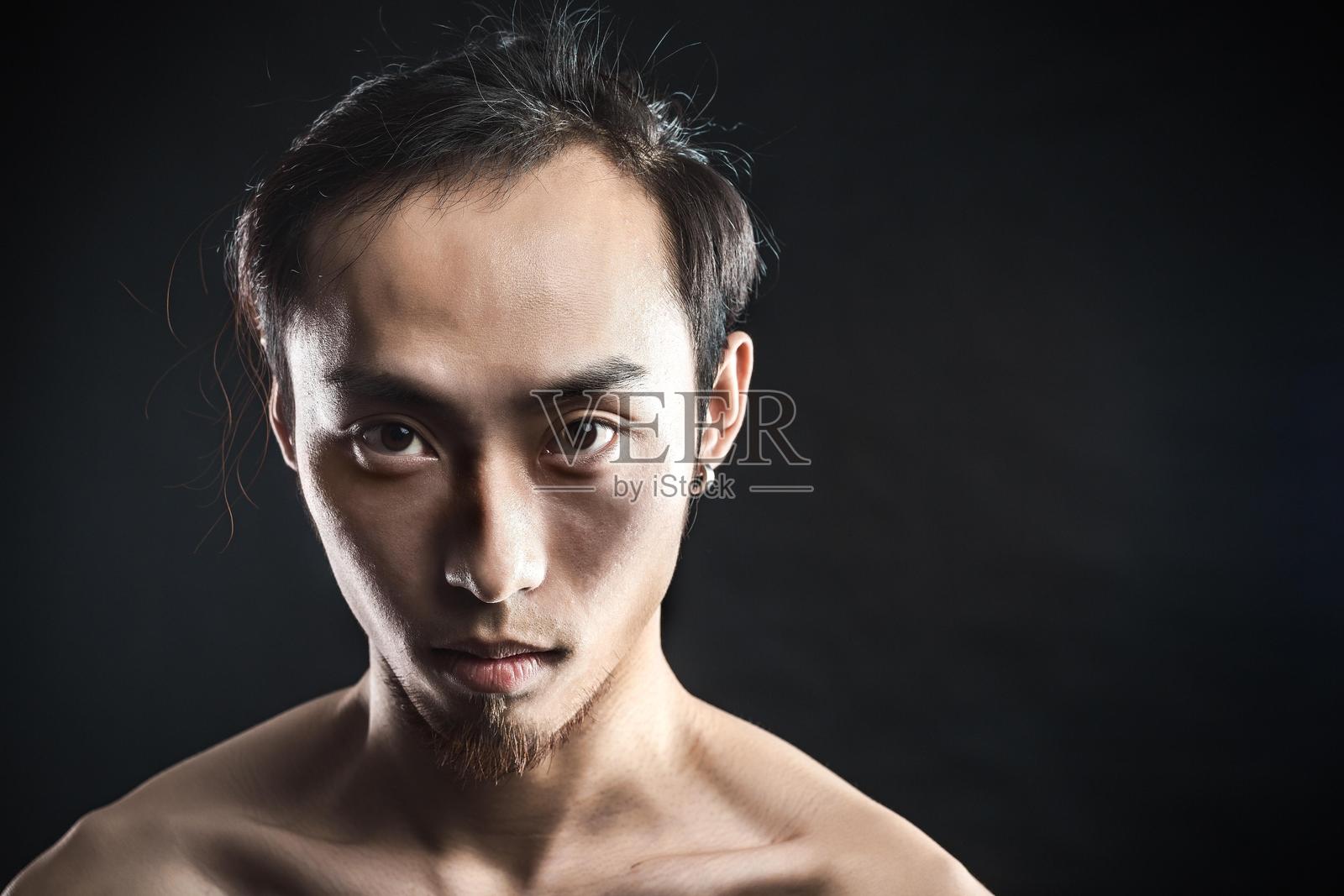 一位年轻亚洲男子面露严肃表情的肖像照片摄影图片