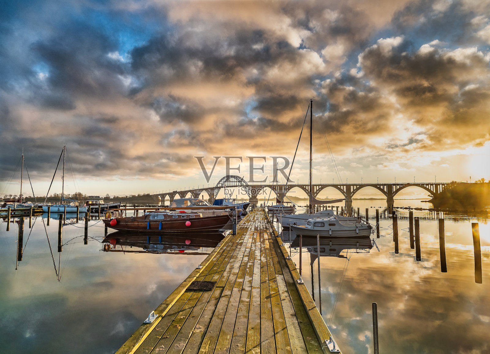 丹麦女王路易丝风景桥下宁静港口的日落照片摄影图片
