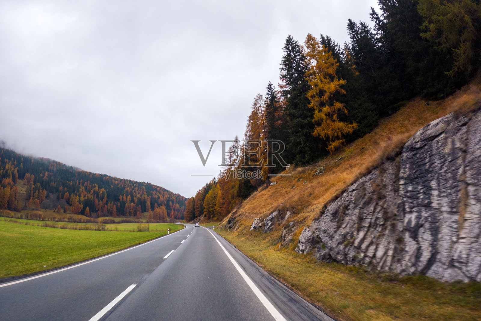 秋色与岩石悬崖间的弯曲道路照片摄影图片