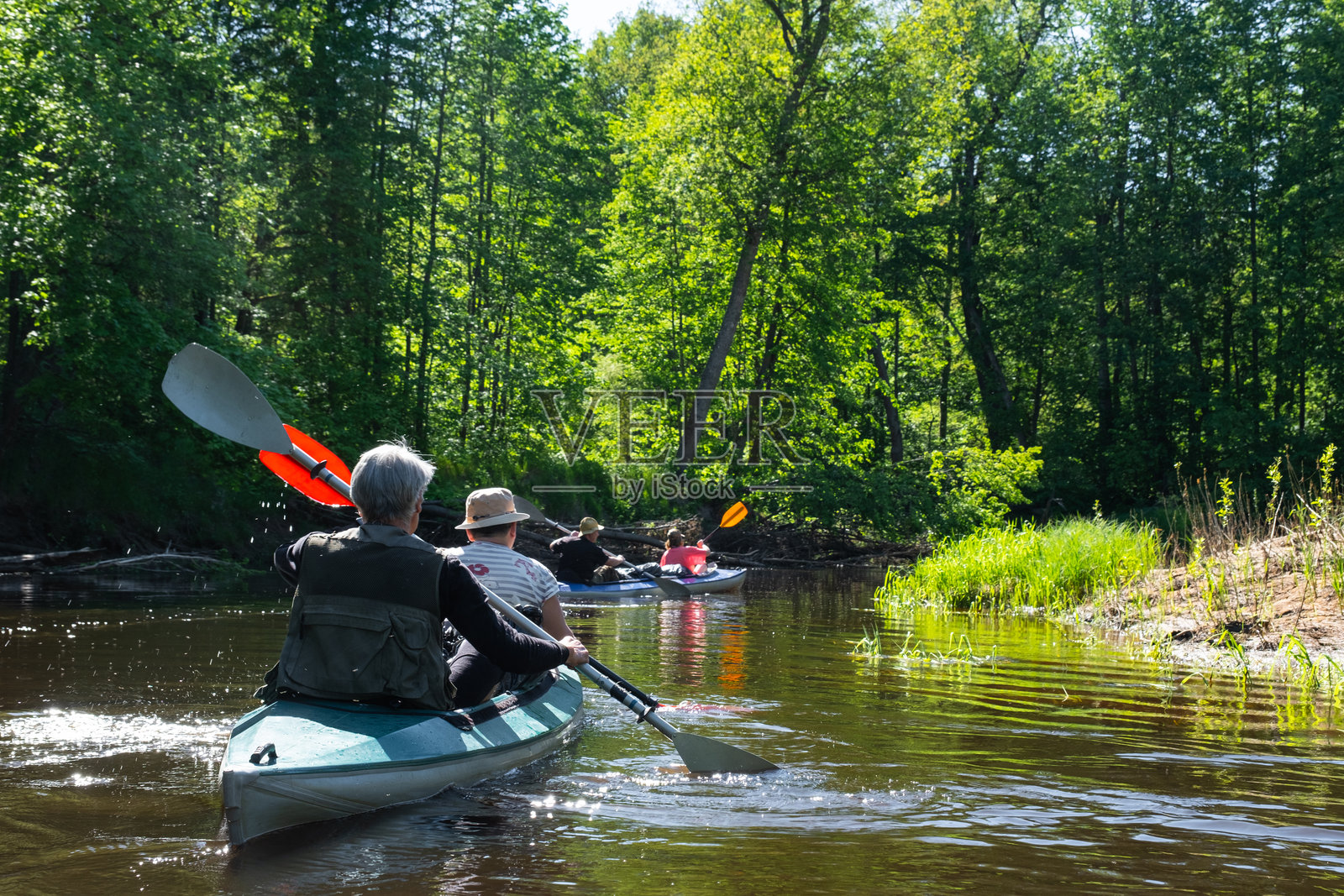 老年夫妇在河上进行团体皮划艇旅行，水上徒步，夏季冒险。与年龄相关的运动，心理年轻与健康，旅游，积极的老年生活。照片摄影图片