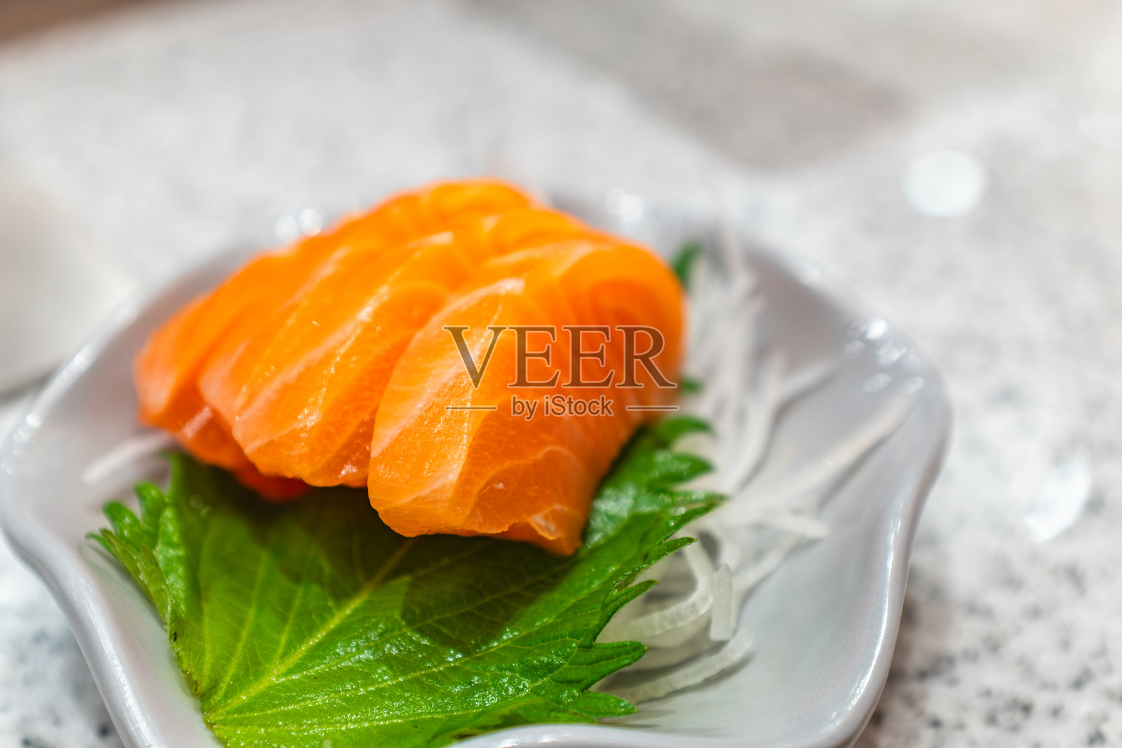 新鲜三文鱼刺身配绿叶蔬菜，日本料理照片摄影图片