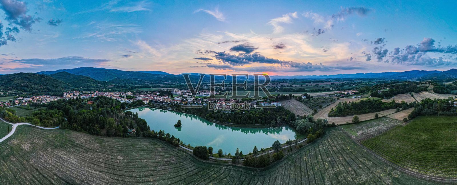 日落时分的乡村风景鸟瞰图，湖泊映衬其中。照片摄影图片