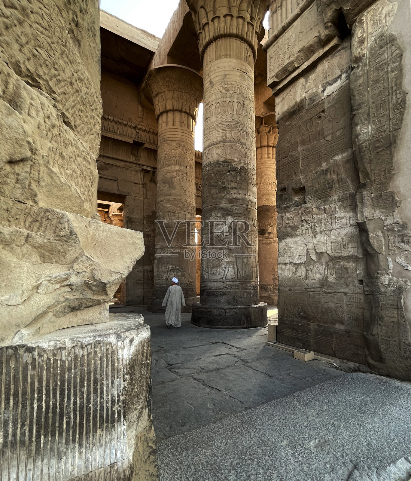 埃及科姆翁博，柱子旁的男子与神庙照片摄影图片