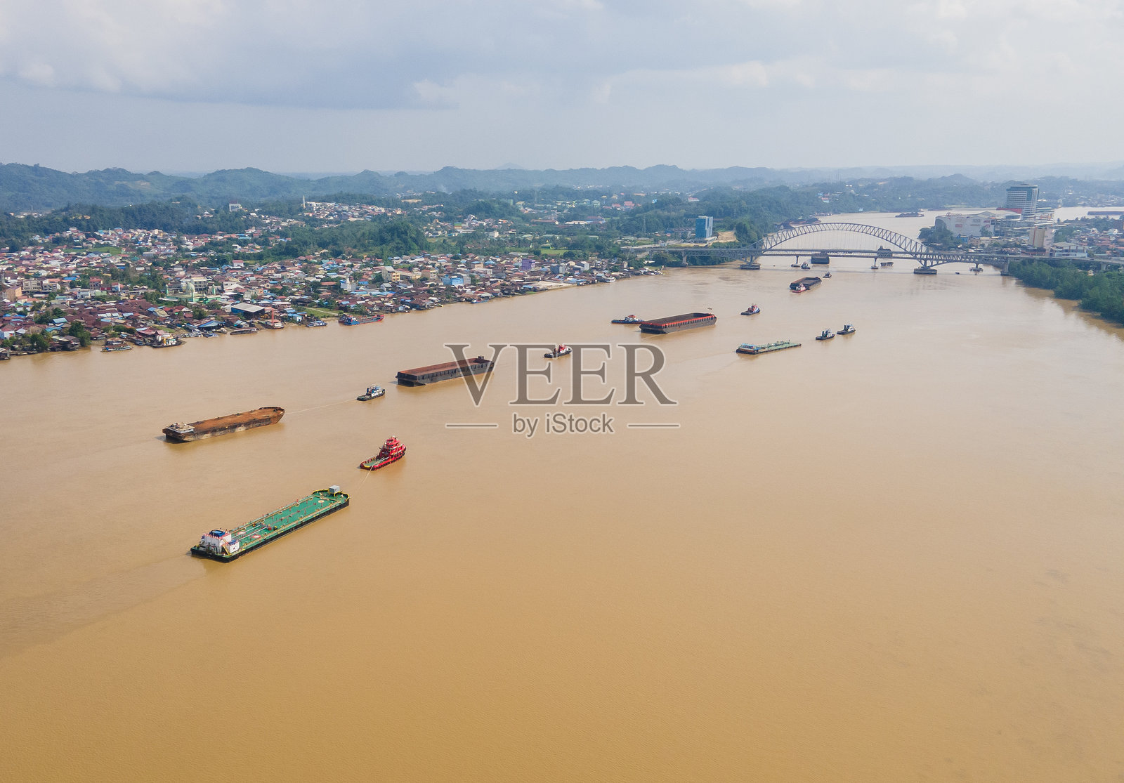 驳船运载煤炭穿越印度尼西亚东加里曼丹省萨马林达市的马哈卡姆河。东加里曼丹以煤炭生产而闻名。照片摄影图片