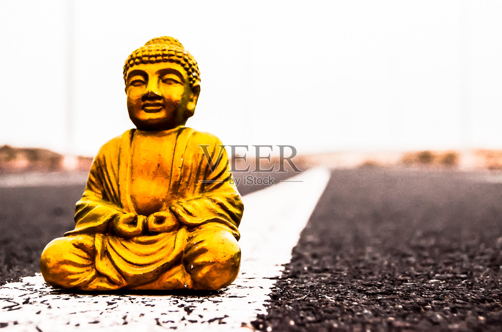 一座金色的佛像坐在路上照片摄影图片