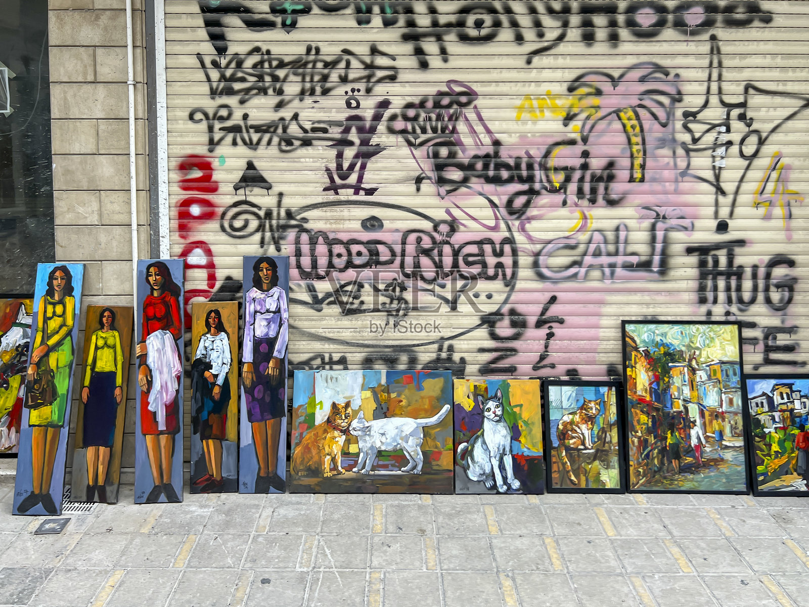 塞浦路斯首都尼科西亚的莱德拉斯街上，靠在房子墙边的涂鸦和各种壁画及待售的画作。照片摄影图片