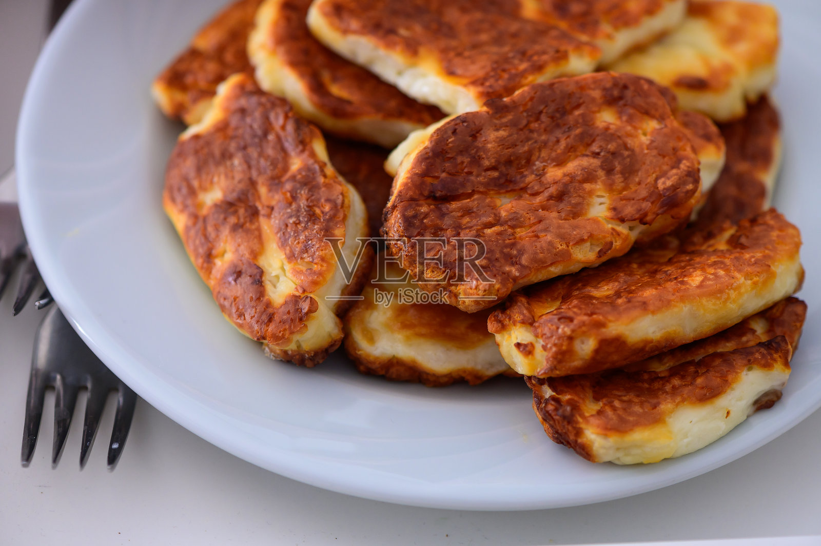 美味的金黄色奶酪酥饼在白色盘子上，适合温馨的下午茶时光。照片摄影图片